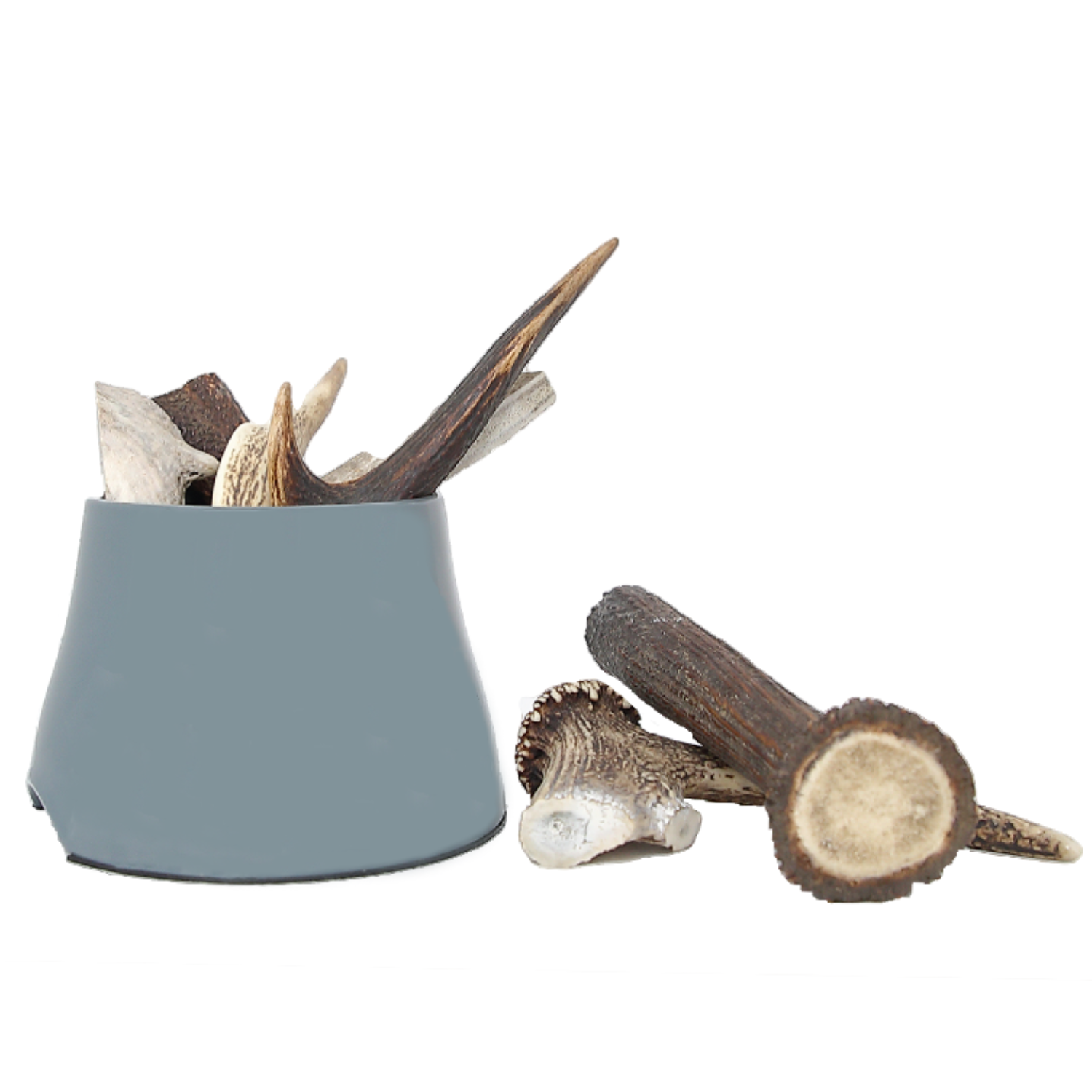 A collection of air dried, frozen deer antlers in various sizes, presented in a gray container. The antlers show different angles and parts, indicating they are intended for dog treats.