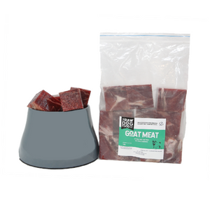 A package of frozen goat meat cubes next to a bowl, indicating the product is pet food.