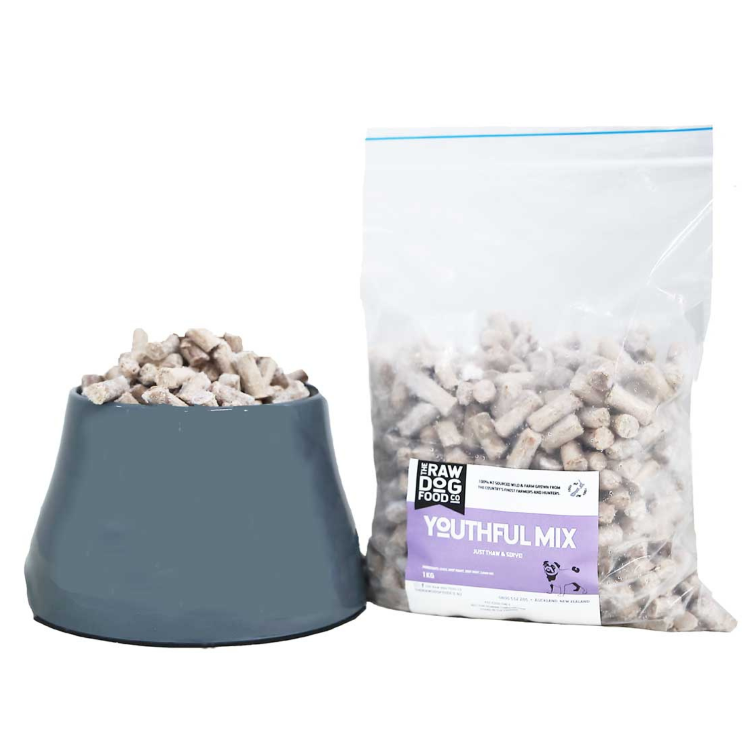 A package of 'Youthful Mix' raw dog food pellets next to a full bowl, indicating the product is a nourishing blend for growing puppies.