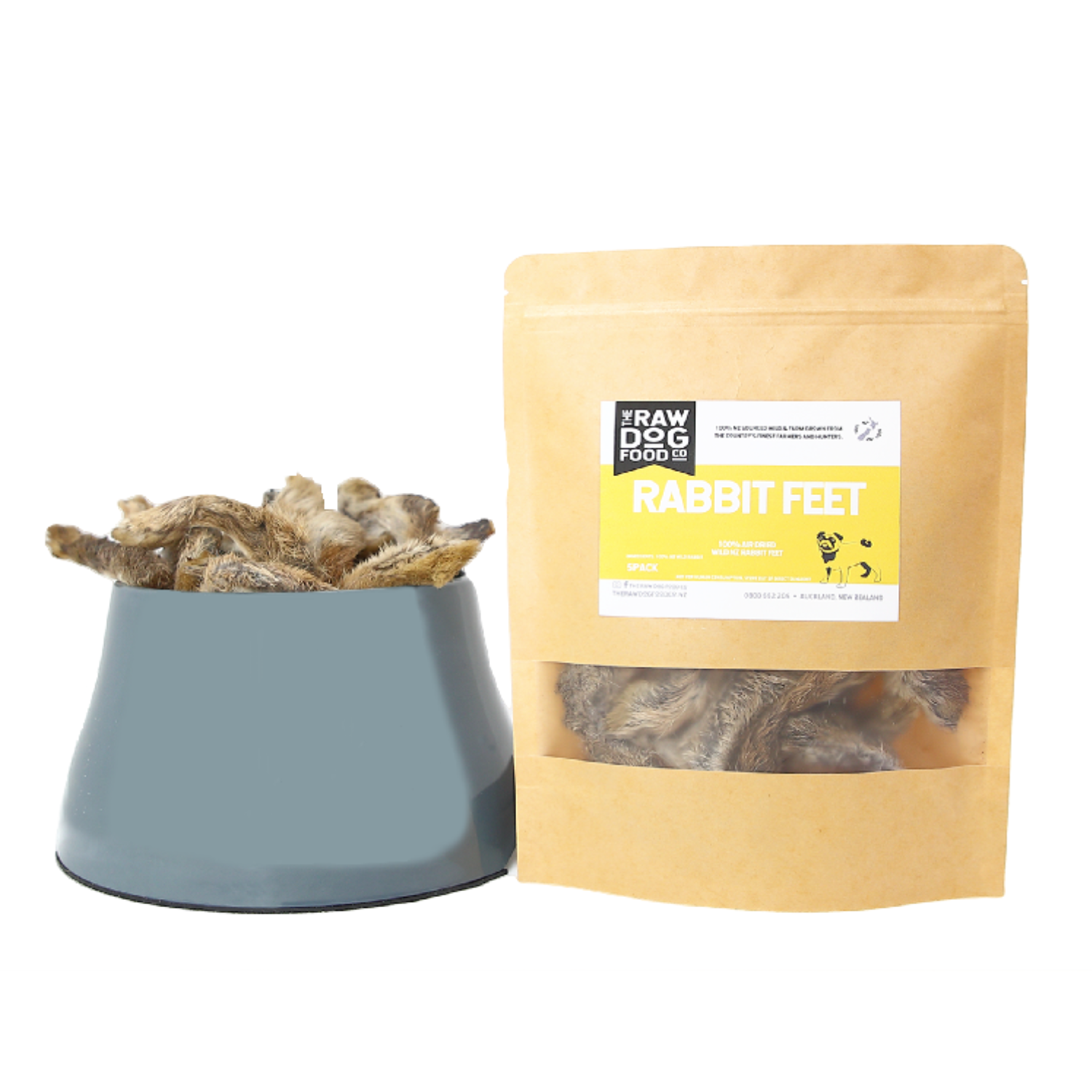 A bowl filled with air-dried rabbit feet next to a packaging labeled 'RABBIT FEET' from The Raw Dog Food Company.