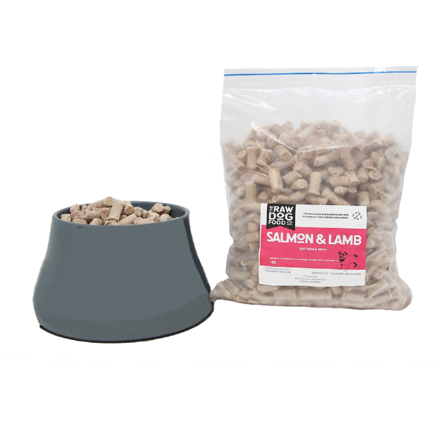 A bag of salmon and lamb pet food pellets next to a bowl filled with the same food.
