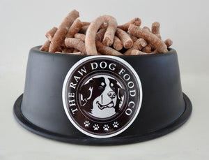 An image of a bowl of salmon and lamb frozen pet food pellets with a white background.