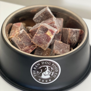 A bowl of frozen horse meat cubes intended for pet food.