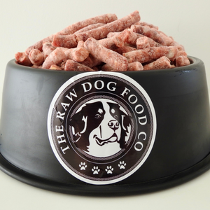 A dog bowl full of frozen energy raw pellets