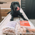 A dog with a bag of frozen raw puppy mix food.